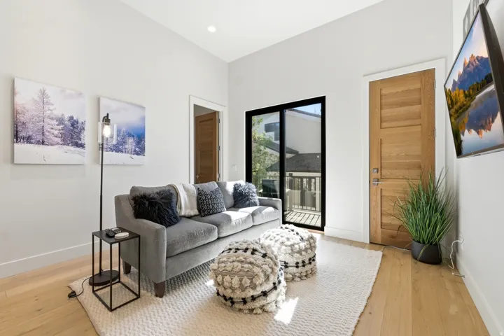 Light wood-finish flooring with a neutral area rug