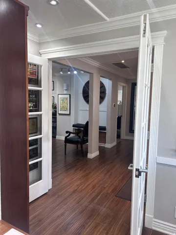 Interior space featuring wood-finish flooring, white paneled doors, and crown molding