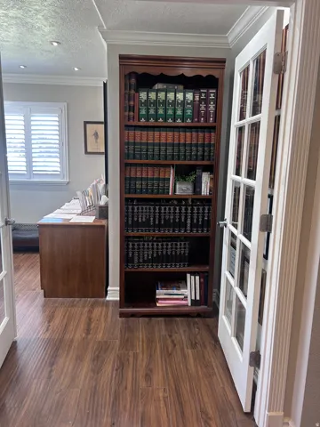 Dedicated home office featuring wood-finish flooring, recessed lighting, and a built-in bookshelf