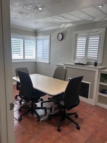 Room featuring terracotta-style floor tiles, recessed ceiling lighting, and white plantation shutters on multiple windows