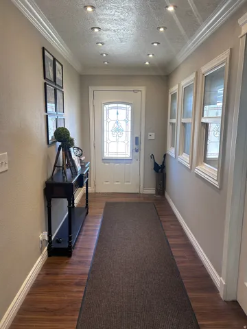 Entryway featuring wood-finish flooring and crown molding