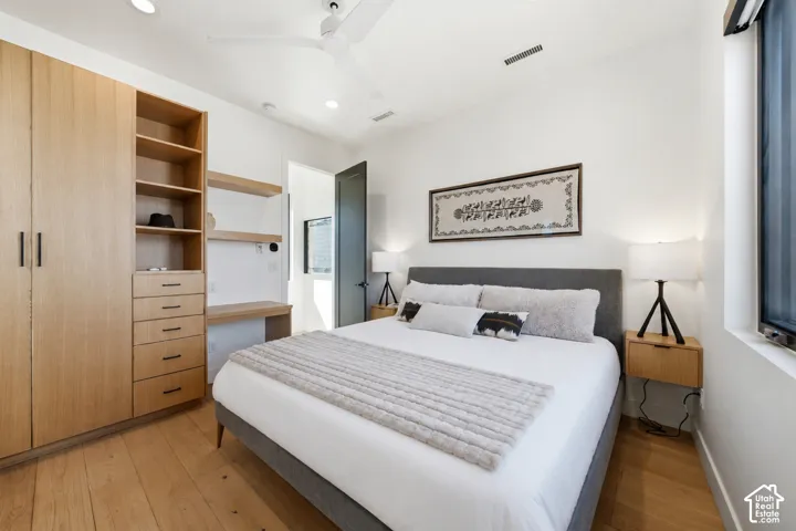 Light wood-finish flooring complements a built-in wardrobe with black hardware