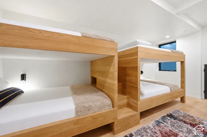 Custom-built wood-finish bunk beds with integrated storage and individual wall sconces