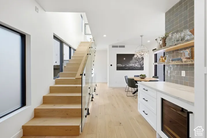 Open-tread staircase with glass railing and natural wood steps