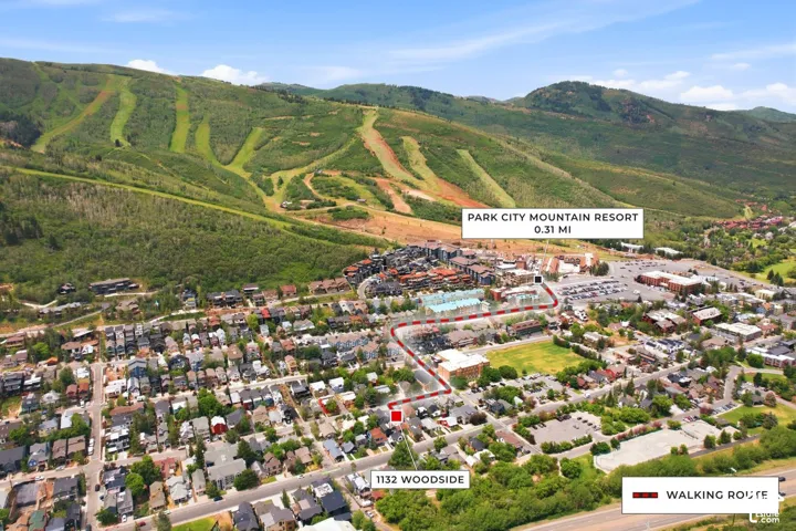 Aerial overview featuring residential properties, commercial establishments, and mountainous terrain