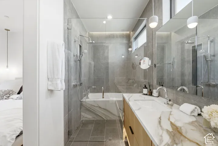Contemporary bathroom featuring a floating wood-finish vanity with a stone-finish countertop, integrated rectangular sink, and chrome fixtures