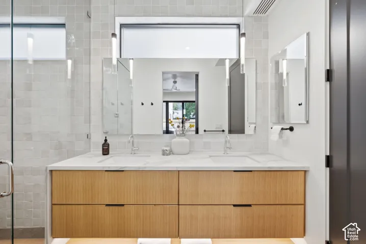 Dual basin vanity with a white countertop and natural wood-finish cabinetry