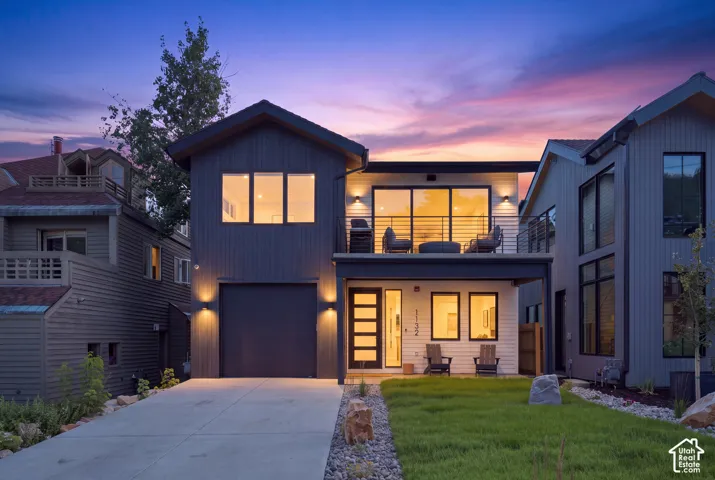 Modern architectural design with a second-story balcony featuring a black metal railing