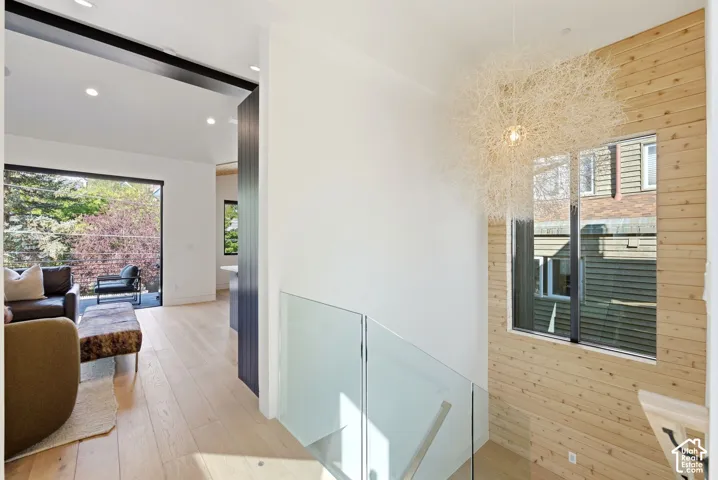 Light wood-finish flooring throughout, complemented by a prominent wood-paneled accent wall