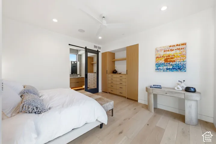 Light wood-finish flooring complements white walls and a white ceiling fan