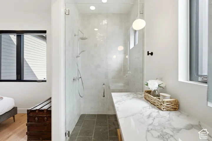 Spacious walk-in shower with a glass enclosure, rain shower head, and an additional handheld shower