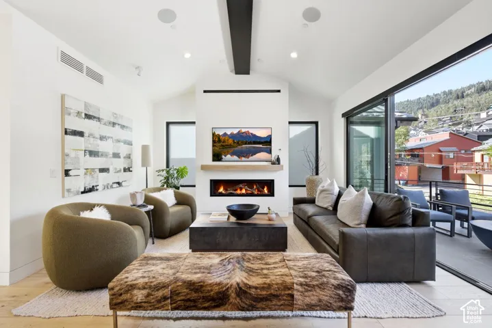 Light wood-finish flooring complements white walls and a vaulted ceiling