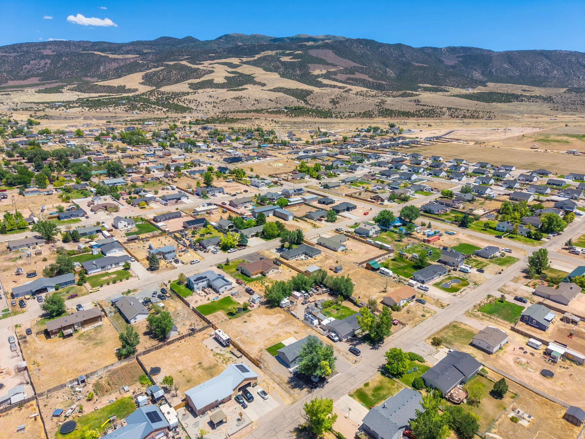 Expansive aerial view of a residential neighborhood with a mountainous backdrop