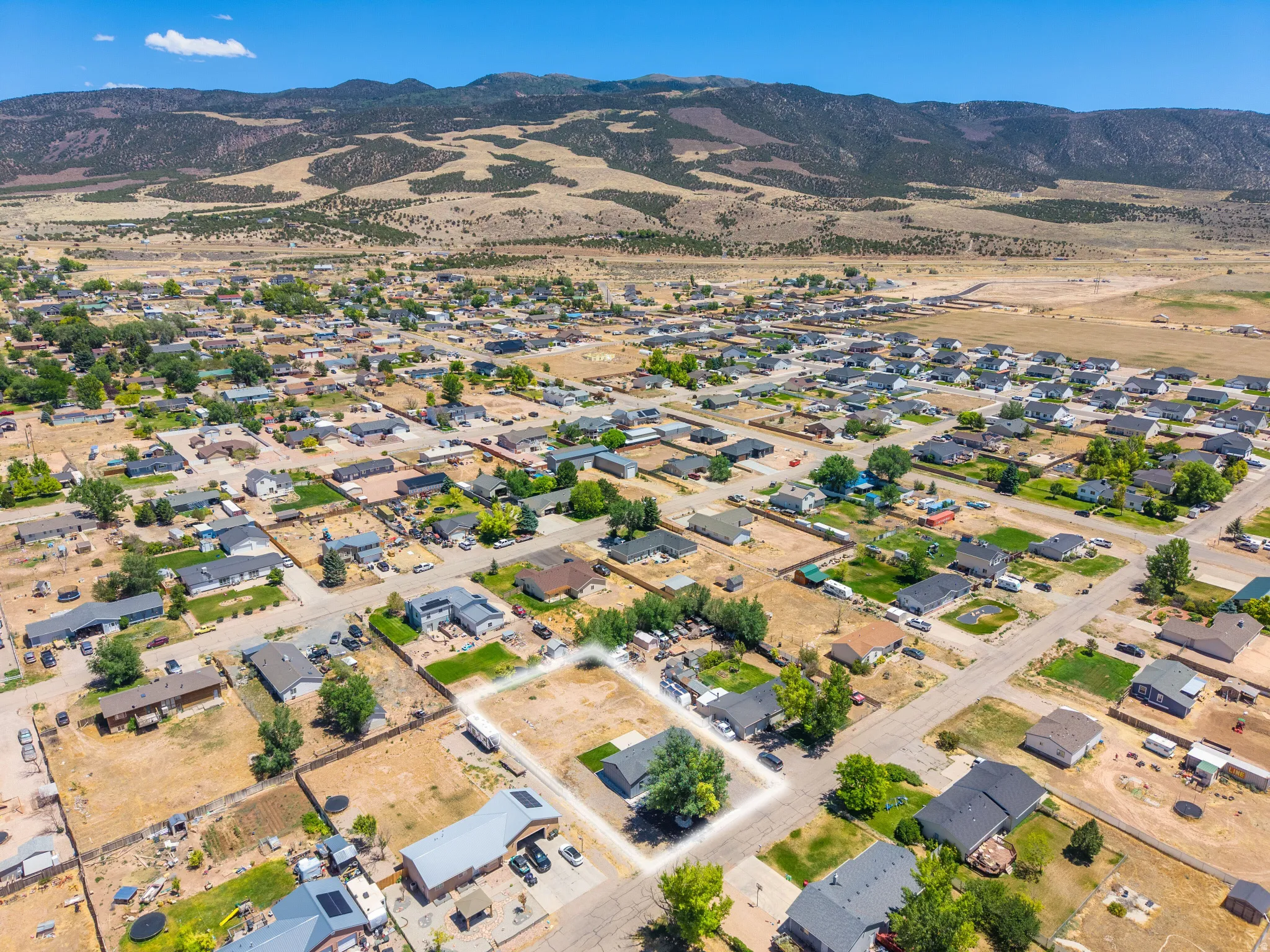 Aerial perspective showcasing a residential neighborhood with mountain backdrop