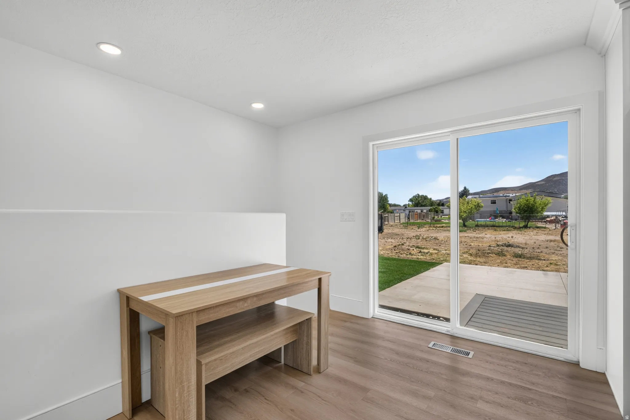 Bright interior space featuring recessed lighting, wood-finish flooring, and white baseboards