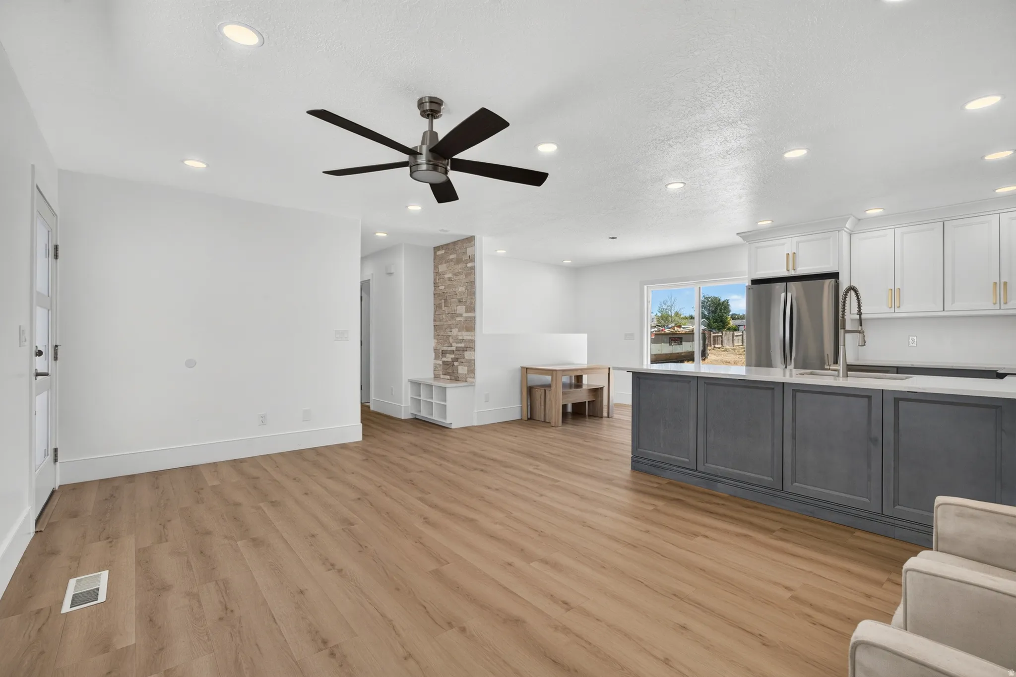 Open-concept living area featuring wood-finish flooring, recessed lighting, and a modern ceiling fan