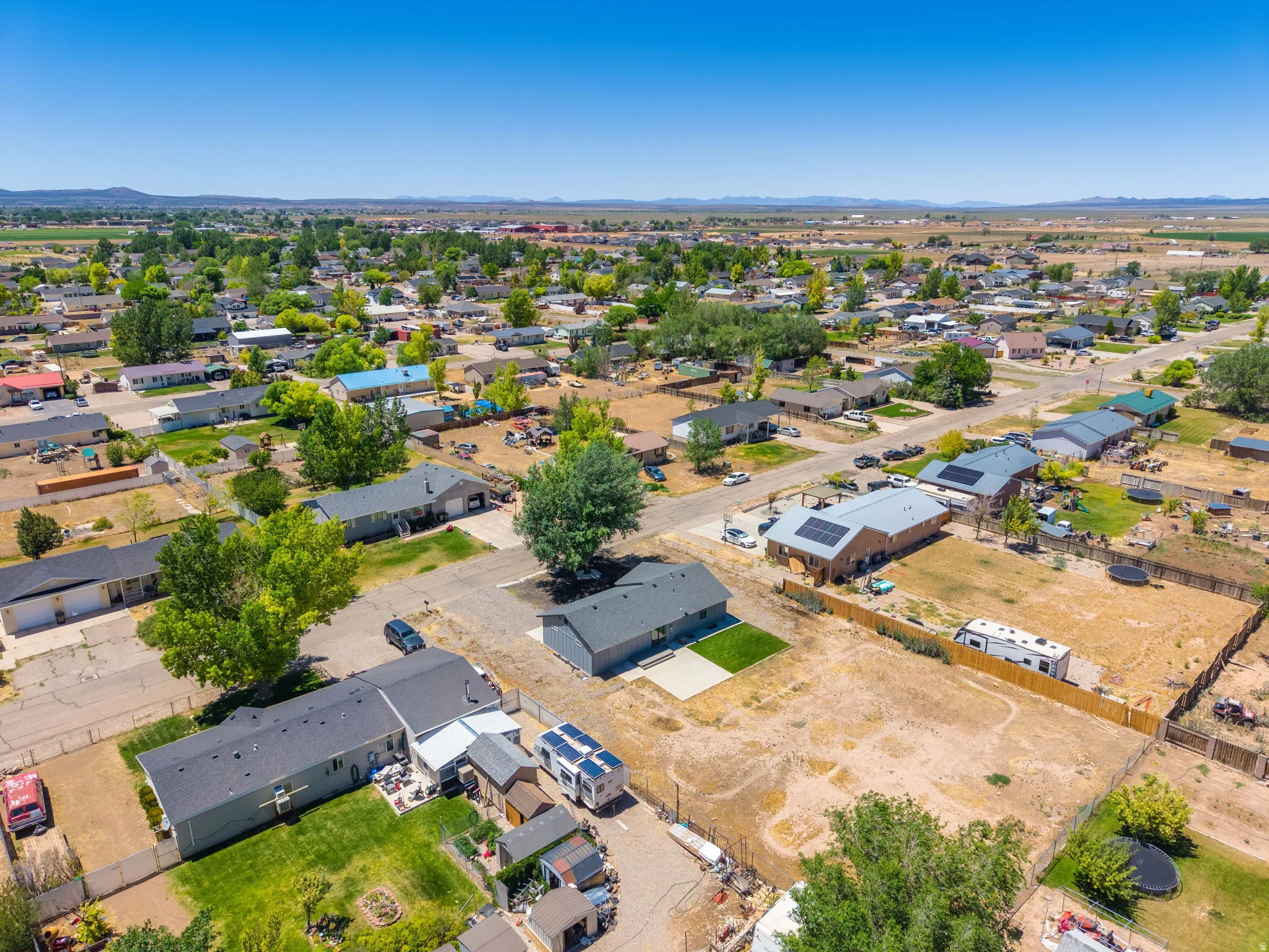 Expansive residential area featuring single-story homes with dark shingle roofs and solar panel installations