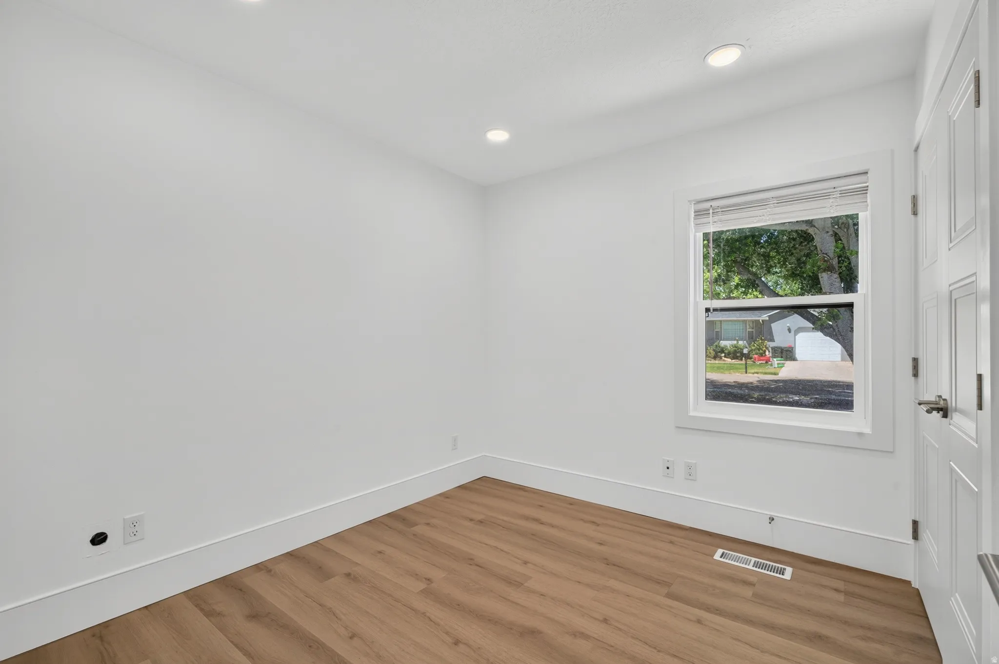 Bright interior space featuring wood-finish flooring and recessed ceiling lights