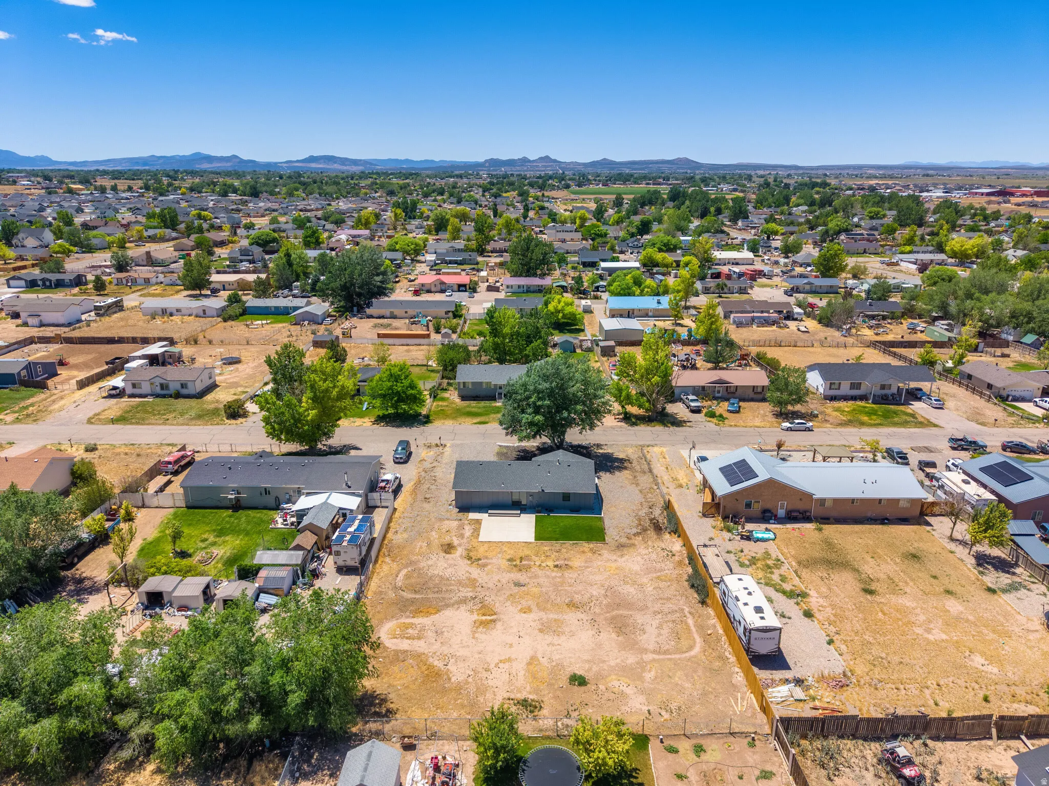 Expansive aerial perspective showcasing a residential neighborhood with distant mountain ranges