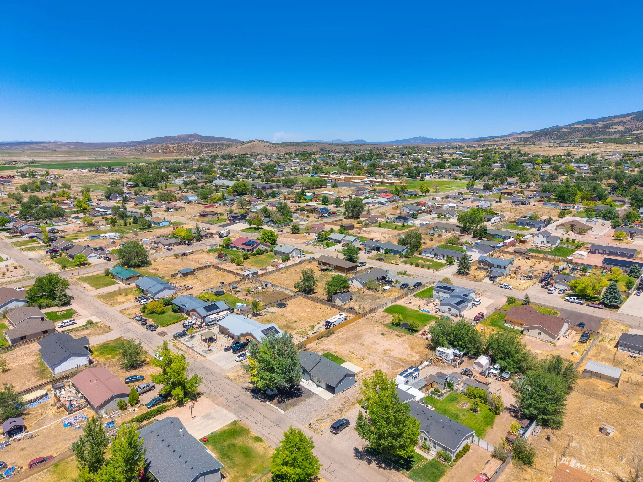 Residential neighborhood under a clear sky, featuring a variety of single-story and two-story homes