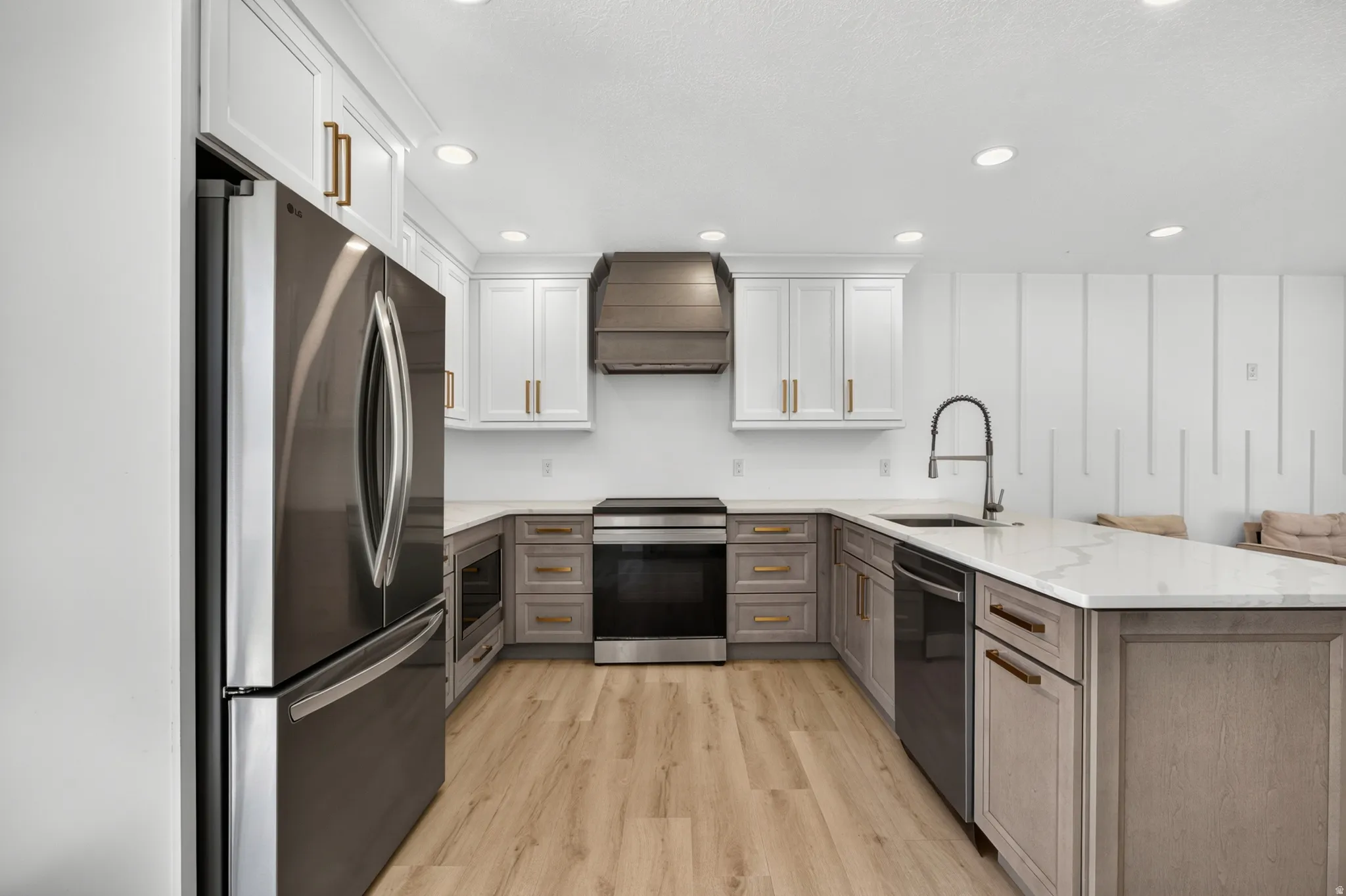 Modern kitchen featuring a two-toned cabinetry design with white upper cabinets and a light wood-finish base