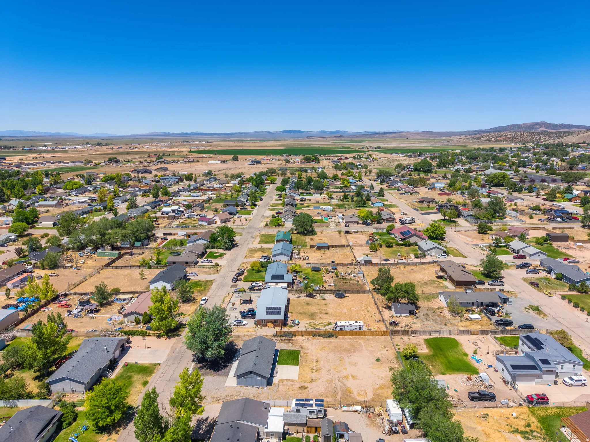 Expansive aerial perspective showcasing a residential area with various single-story homes, many featuring private yards