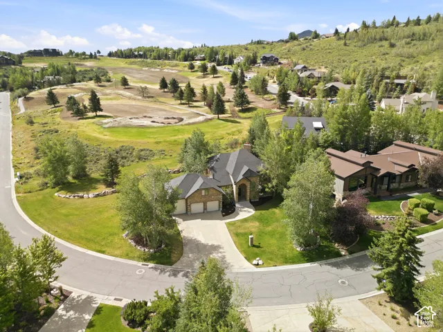 Property featuring a paved driveway, attached two-car garage, and a lush green lawn