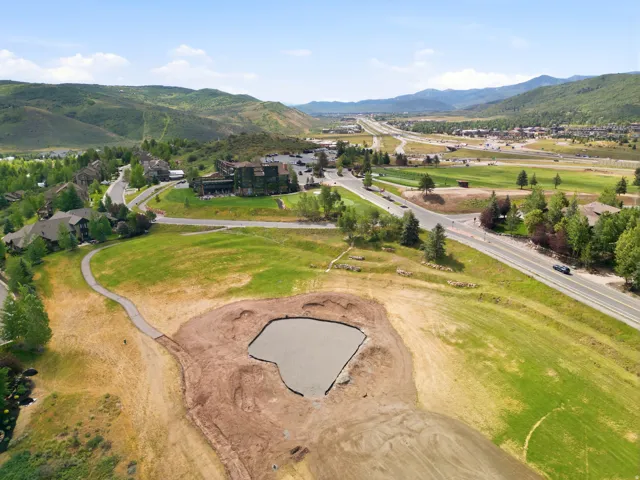 Expansive lot featuring a prepared pad for construction and a surrounding grassy area