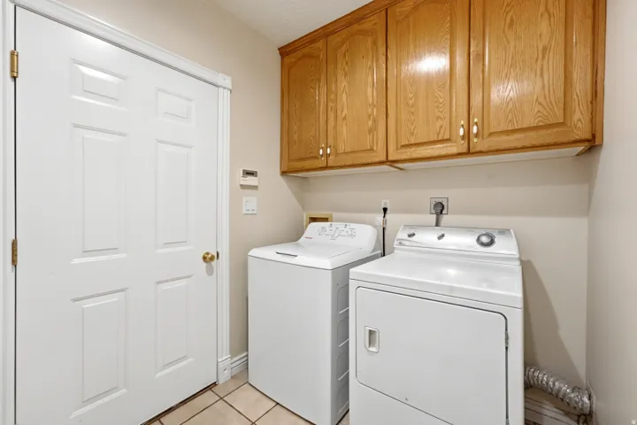 Dedicated utility space featuring light wood-finish cabinetry