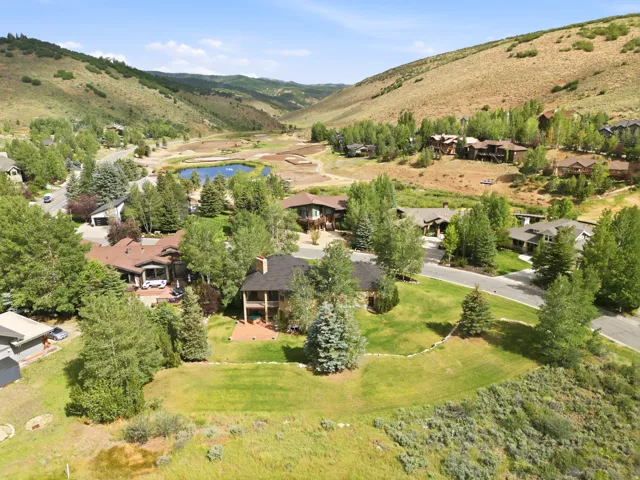 Lush green landscaping with mature trees surrounding the property
