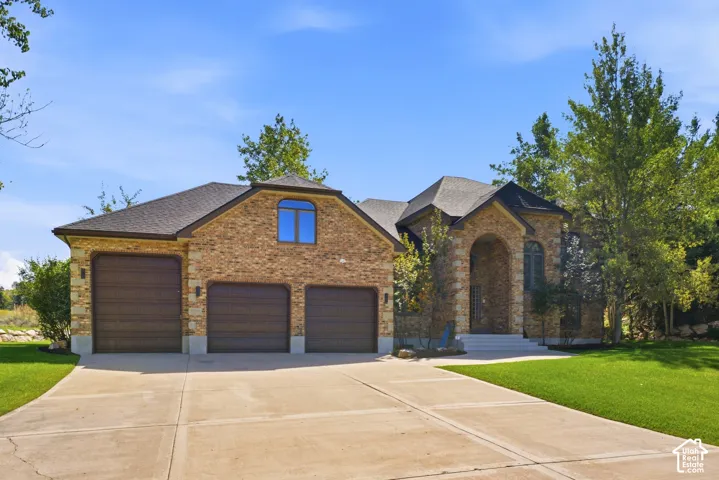 Stone and brick exterior with a three-car garage and arched entry