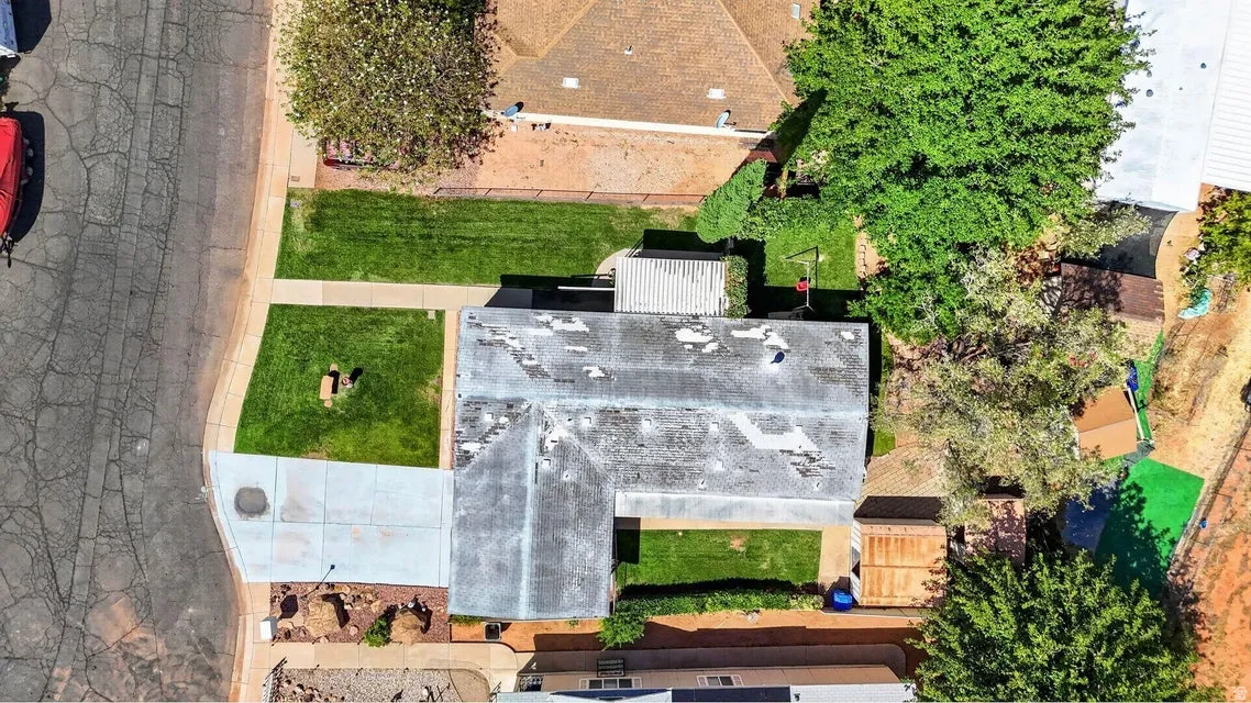 Overhead property view featuring a light-colored roof, a concrete driveway, and front and rear lawn areas
