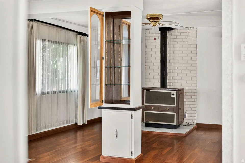 Warm wood-finish flooring complements a built-in display cabinet with glass shelving and a lower storage cabinet