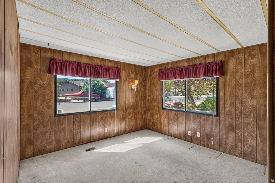 Interior space featuring wood-finish paneling and wall-to-wall carpeting