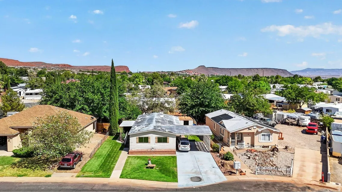 Single-story residence featuring a covered carport, a paved driveway, and a manicured front lawn