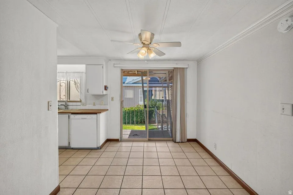 Dining area featuring tile flooring, a ceiling fan, crown molding, and sliding glass doors opening to the exterior