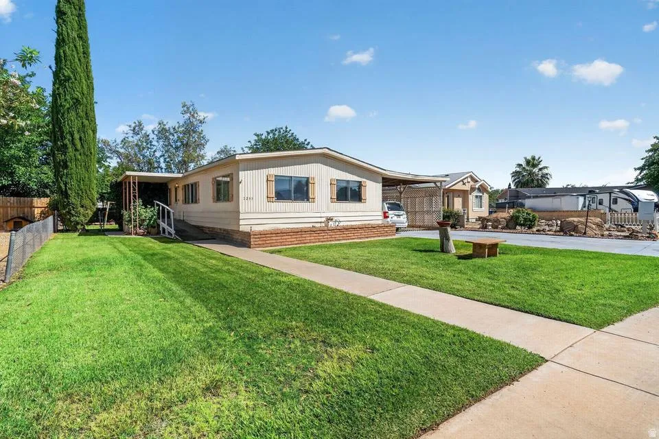 Single-story residence featuring light-colored siding and a brick-look foundation