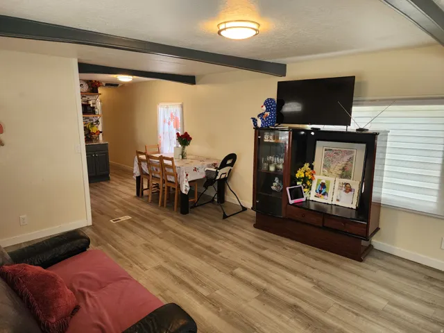 Open-concept living area with wood-finish flooring extending into the dining space