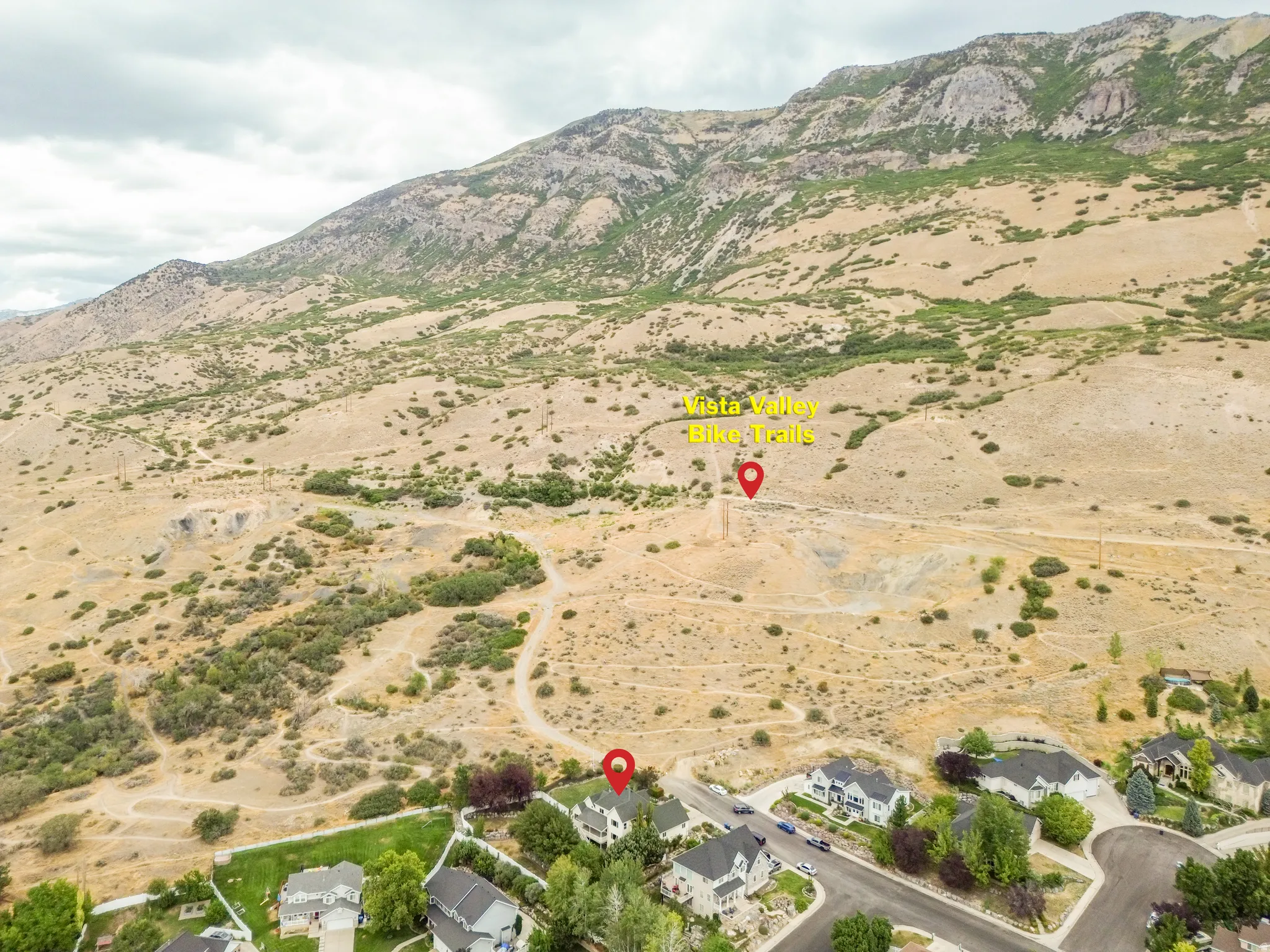 Mountainous backdrop with natural terrain and visible bike trails