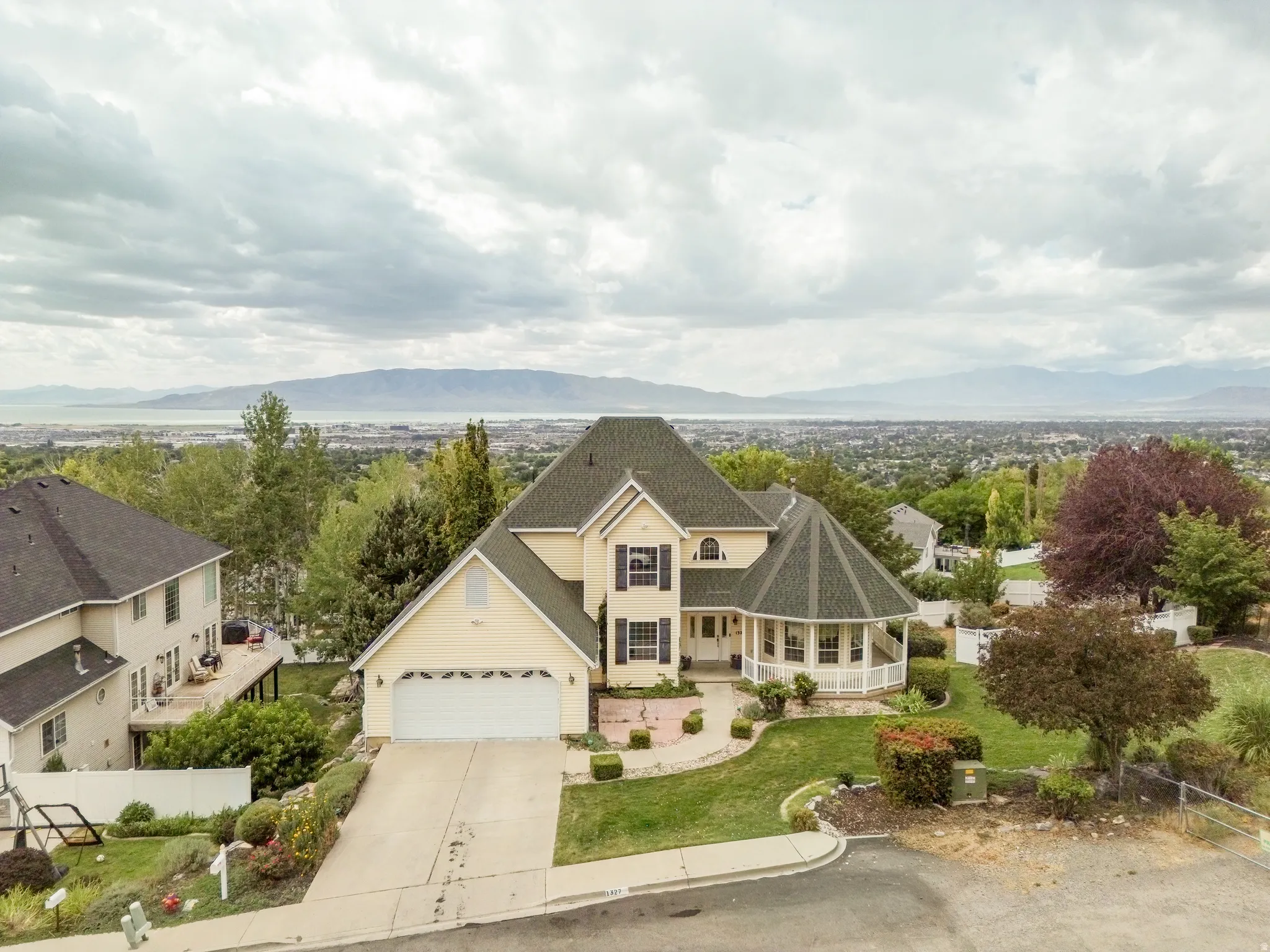 Two-story residence featuring a prominent turret, covered front porch, and an attached garage