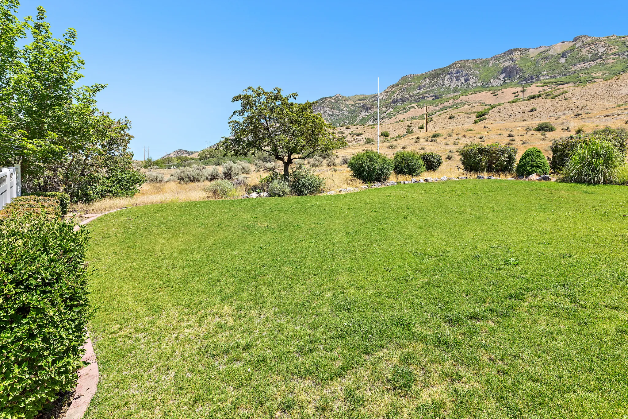 Expansive lawn bordered by a low hedge and a decorative stone edge