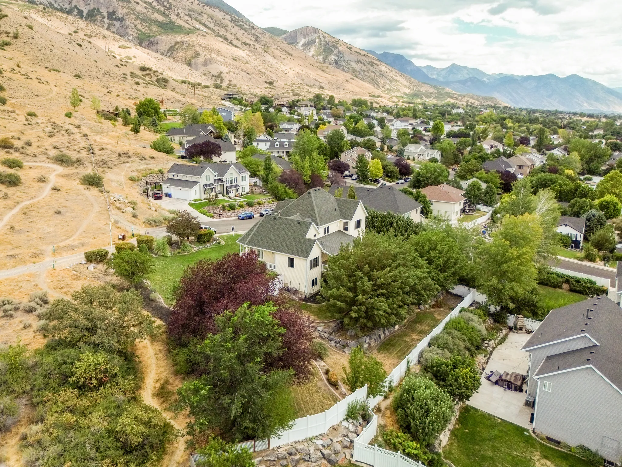 Expansive residential area featuring numerous properties, mountainous backdrop, and mature landscaping