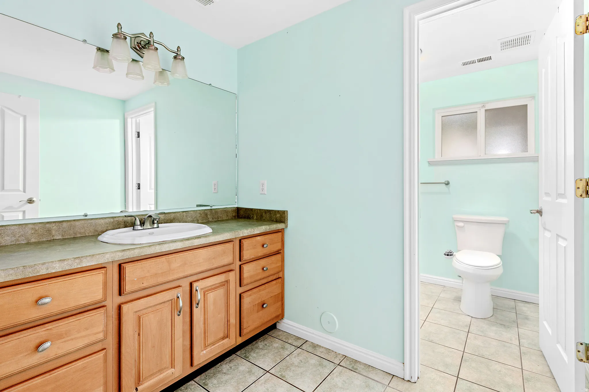 Bathroom vanity featuring an integrated sink with a chrome faucet, set within a neutral-toned countertop