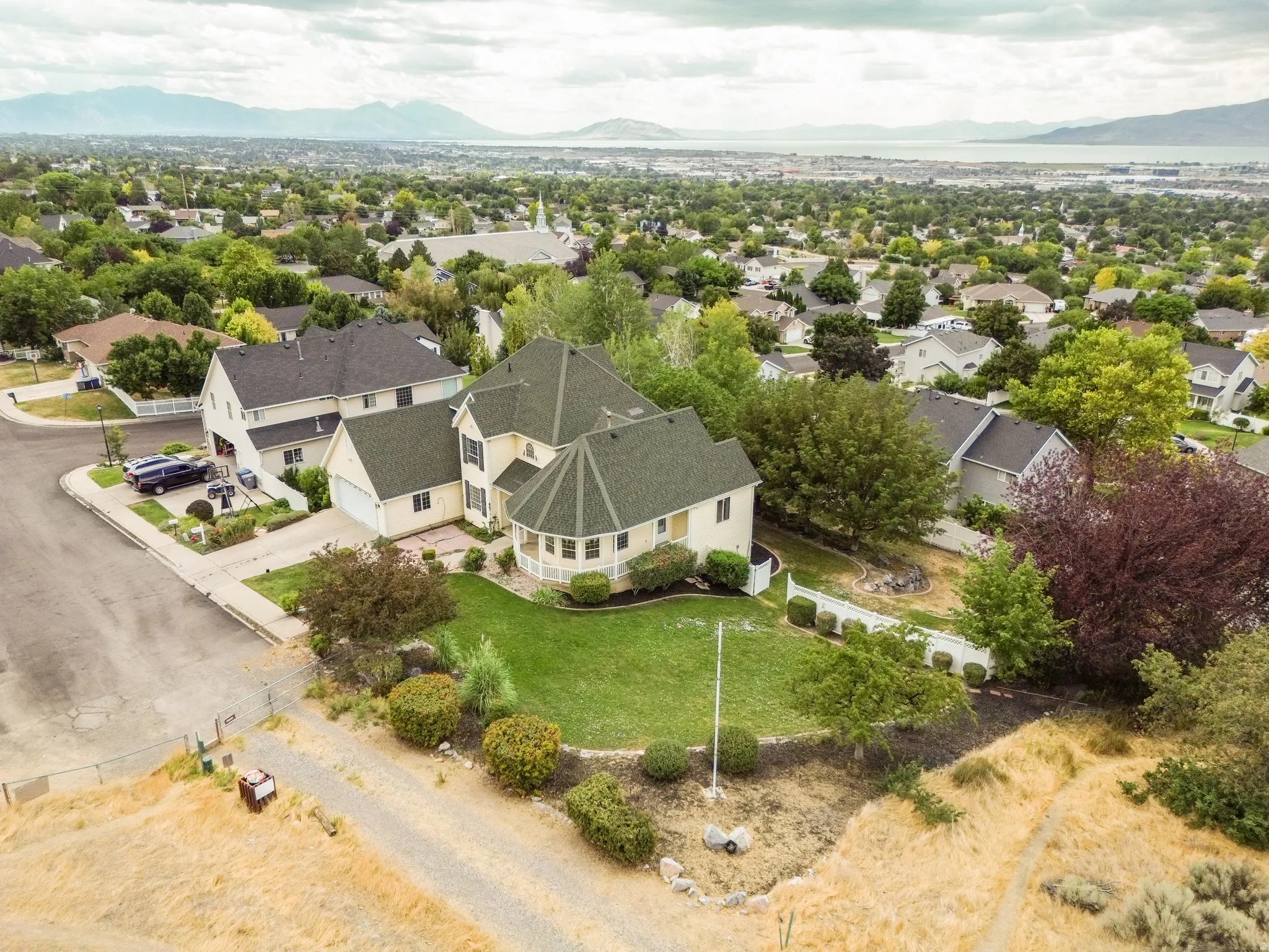 Spacious property featuring a landscaped front yard, two-story residence with a turret, and a paved driveway