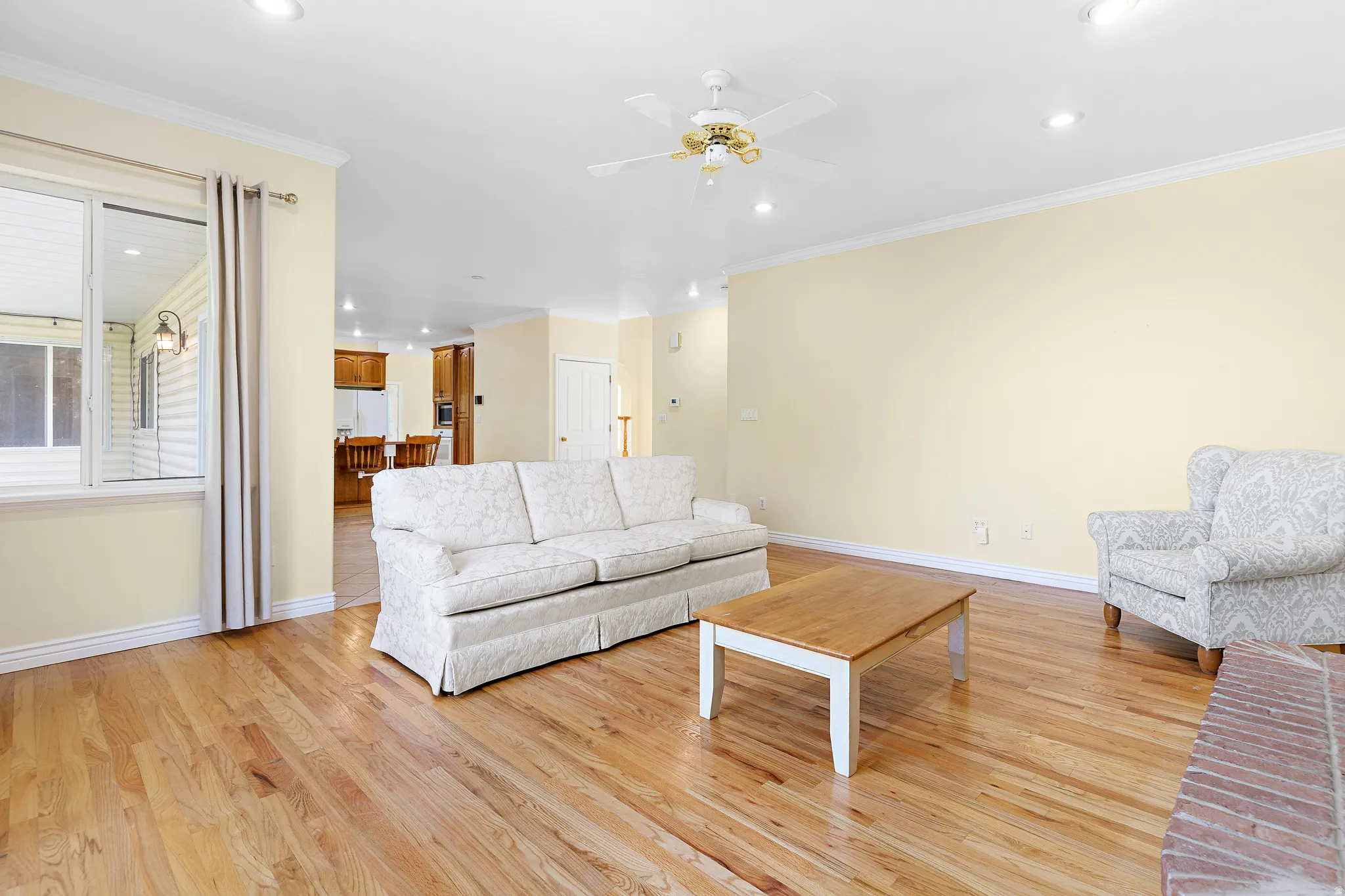 Open-concept living space featuring wood-finish flooring, recessed lighting, and a ceiling fan
