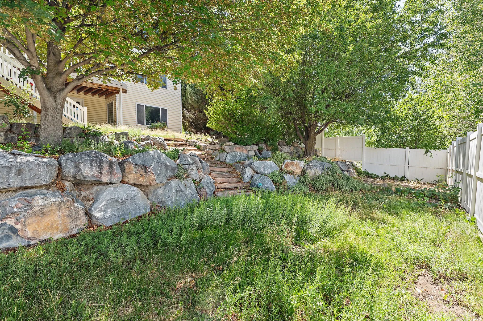 Tiered landscaping featuring large boulders and stone steps