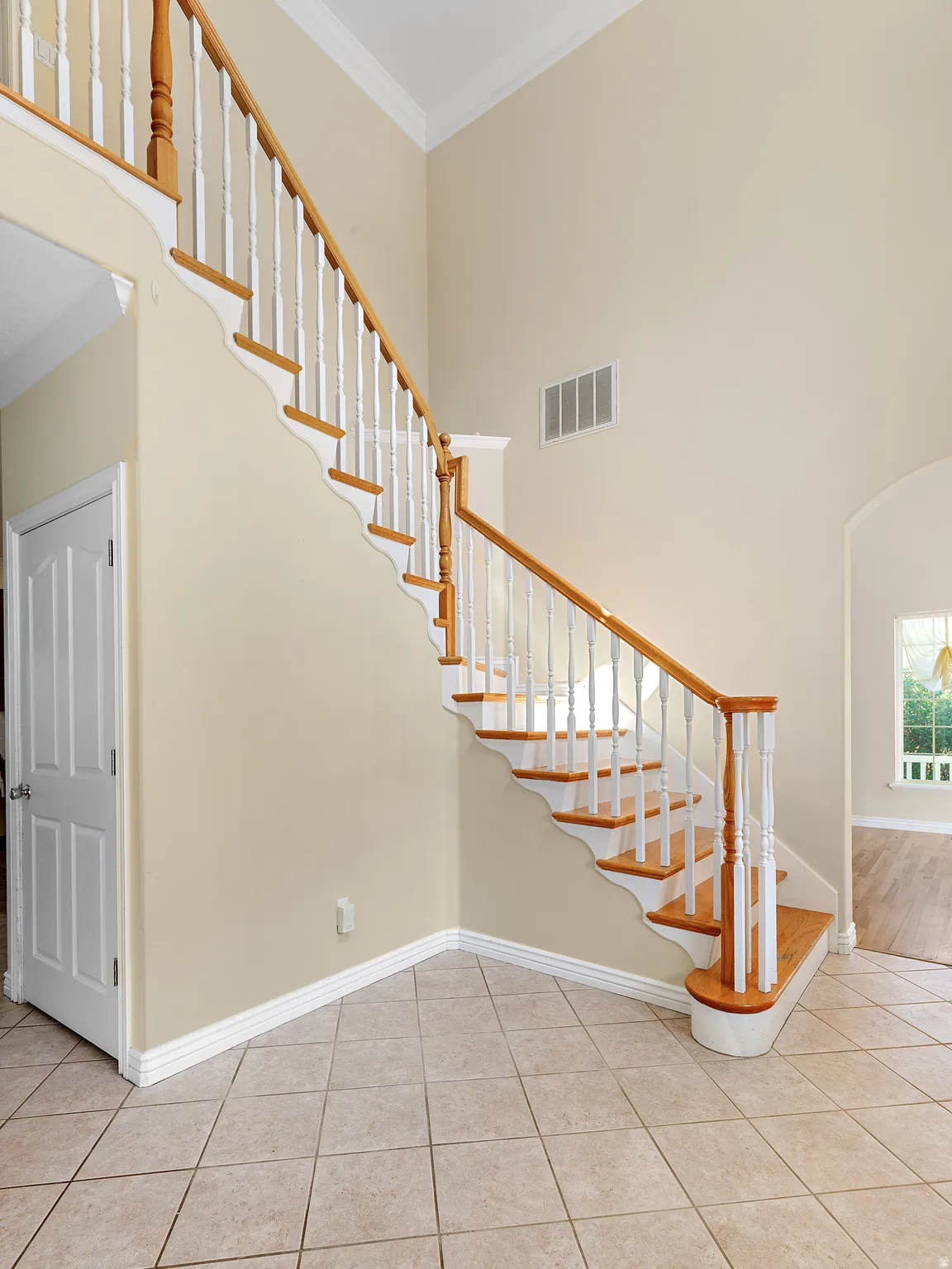 Two-story entry featuring a staircase with wood treads, painted white risers, and wood newel posts