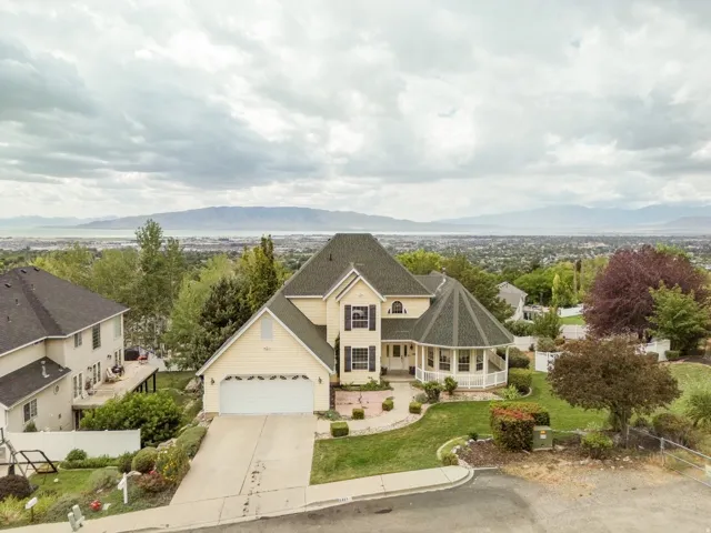 Two-story residence featuring a prominent turret, covered front porch, and an attached garage