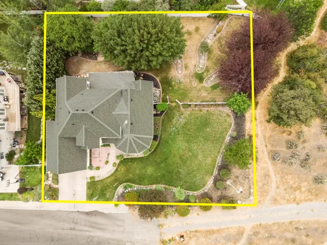 Expansive property featuring a multi-gabled roof, mature trees, manicured lawns, and established landscaping