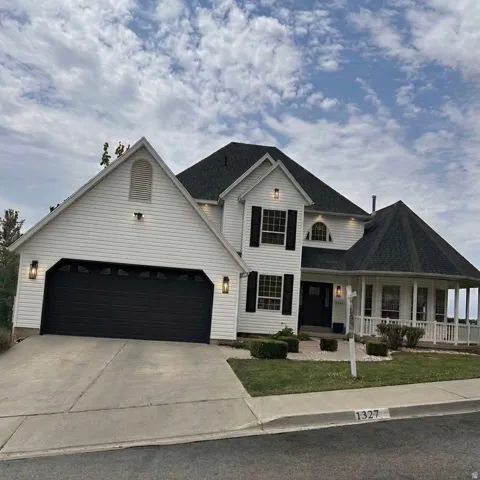 AI generated image by Make It Market Ready. White siding exterior with a dark shingle roof, featuring a two-car garage with a dark door